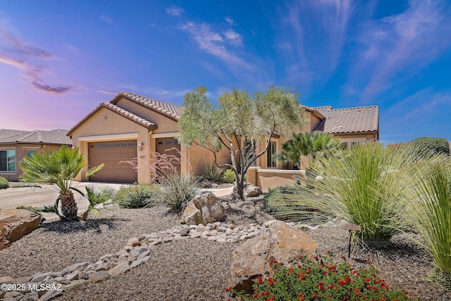 61050 E Amur Ln, Oracle, AZ 85623 - view of front of property with a tile roof, an attached garage, stucco siding, and concrete driveway