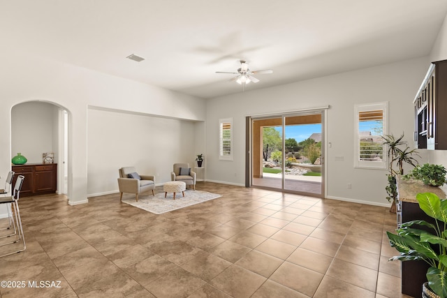 61050 E Amur Ln, Oracle, AZ 85623 - living area with plenty of natural light, arched walkways, ceiling fan, and baseboards