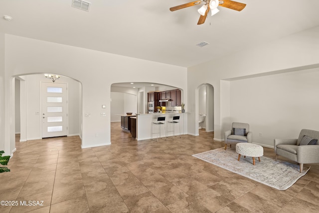 61050 E Amur Ln, Oracle, AZ 85623 - living room featuring arched walkways, a ceiling fan, baseboards, and light tile patterned flooring