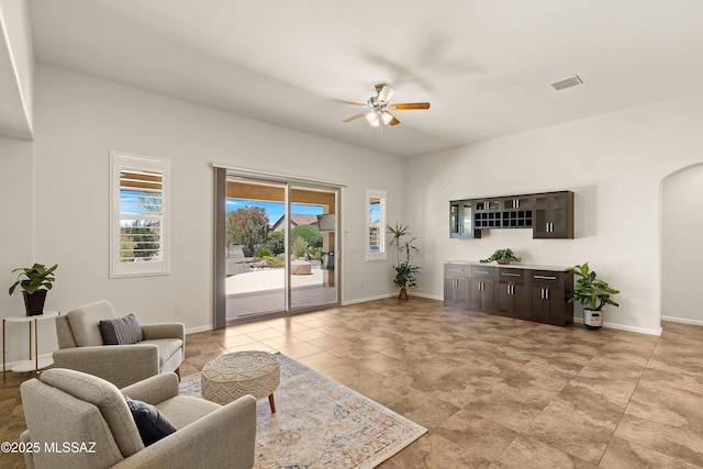 61050 E Amur Ln, Oracle, AZ 85623 - living room with arched walkways, a ceiling fan, and baseboards
