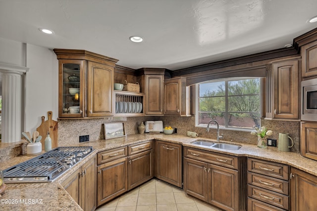 6945 N Mona Lisa Rd, Tucson, AZ 85741 - kitchen featuring a sink, tasteful backsplash, light tile patterned floors, light stone counters, and glass insert cabinets