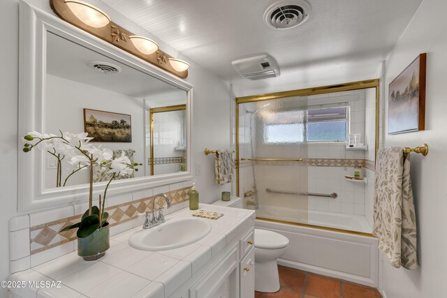 6945 N Mona Lisa Rd, Tucson, AZ 85741 - full bath with vanity, toilet, decorative backsplash, shower / bath combination with glass door, and tile patterned floors