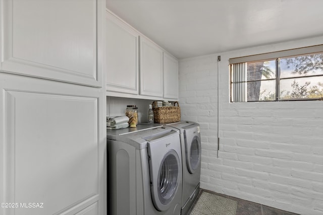 6945 N Mona Lisa Rd, Tucson, AZ 85741 - laundry room featuring washer and clothes dryer, cabinet space, and brick wall