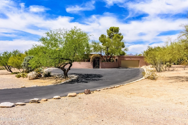 6945 N Mona Lisa Rd, Tucson, AZ 85741 - view of front of house with driveway, a garage, and brick siding