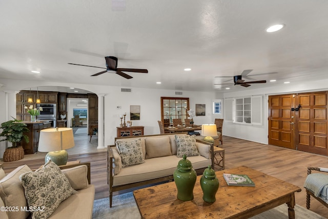 6945 N Mona Lisa Rd, Tucson, AZ 85741 - living room with ceiling fan, arched walkways, recessed lighting, light wood-style floors, and ornate columns