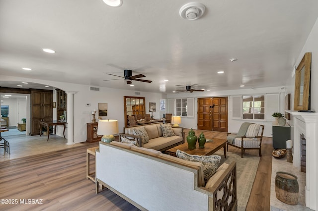 6945 N Mona Lisa Rd, Tucson, AZ 85741 - living area featuring ceiling fan, light wood finished floors, recessed lighting, arched walkways, and a fireplace