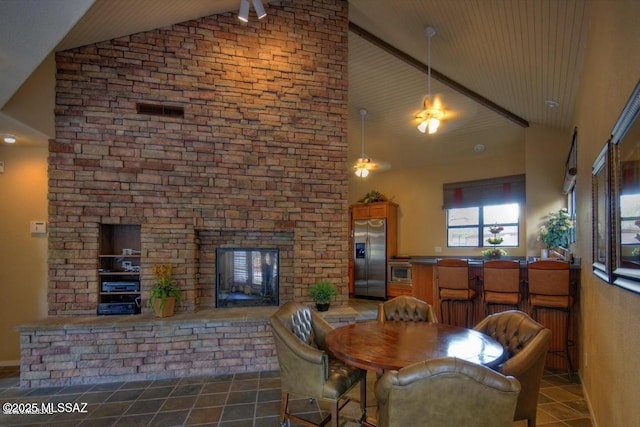 5800 N Kolb Rd Unit 11259, Tucson, AZ 85750 - dining room with dark tile patterned flooring, high vaulted ceiling, and a large fireplace