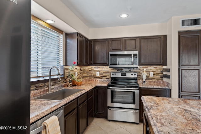 941 W Fox Ridge Ln, Oro Valley, AZ 85737 - kitchen featuring appliances with stainless steel finishes, a sink, dark brown cabinets, and decorative backsplash