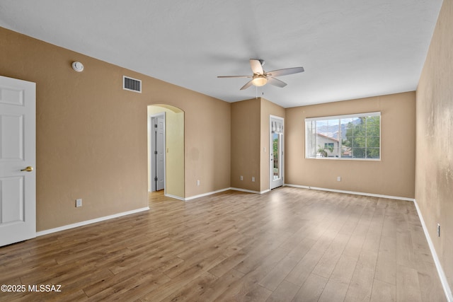 941 W Fox Ridge Ln, Oro Valley, AZ 85737 - spare room featuring arched walkways, a ceiling fan, wood finished floors, baseboards, and a smoke detector