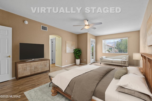 941 W Fox Ridge Ln, Oro Valley, AZ 85737 - bedroom featuring arched walkways, wood finished floors, baseboards, and ceiling fan