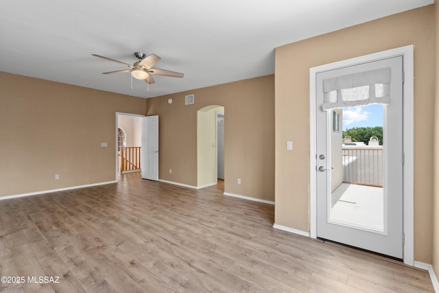 941 W Fox Ridge Ln, Oro Valley, AZ 85737 - unfurnished room featuring arched walkways, ceiling fan, light wood finished floors, and baseboards