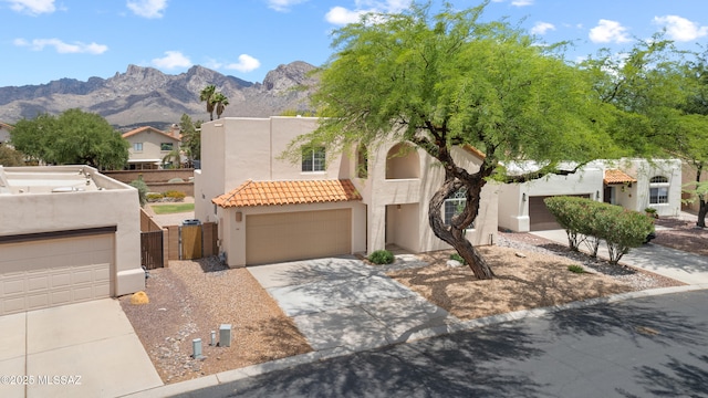 941 W Fox Ridge Ln, Oro Valley, AZ 85737 - view of front facade with stucco siding, concrete driveway, a gate, a tiled roof, and a mountain view