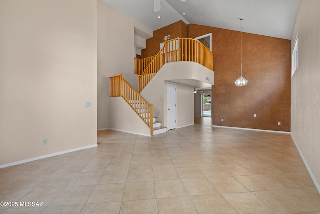 941 W Fox Ridge Ln, Oro Valley, AZ 85737 - unfurnished living room with a ceiling fan, stairs, high vaulted ceiling, baseboards, and light tile patterned floors