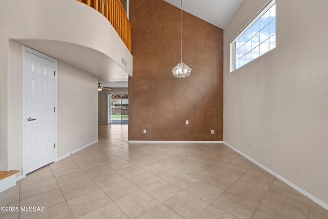 941 W Fox Ridge Ln, Oro Valley, AZ 85737 - empty room with a high ceiling, a chandelier, healthy amount of natural light, light tile patterned floors, and baseboards
