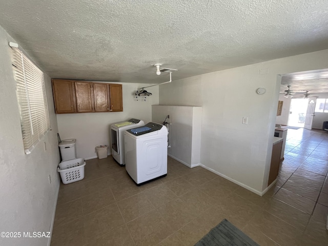 1202 E 26th St, Tucson, AZ 85713 - laundry room with separate washer and dryer, dark tile patterned flooring, a textured ceiling, cabinet space, and baseboards