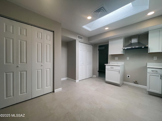 2330 N Los Altos Ave, Tucson, AZ 85705 - kitchen with wall chimney exhaust hood, a skylight, baseboards, light countertops, and recessed lighting