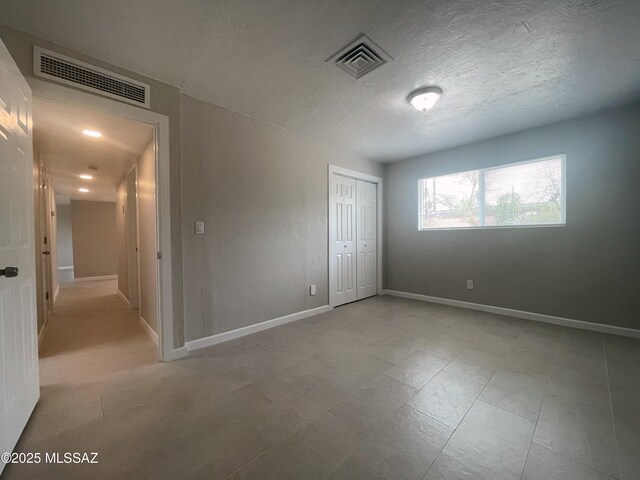 2330 N Los Altos Ave, Tucson, AZ 85705 - unfurnished bedroom featuring a closet and a textured ceiling