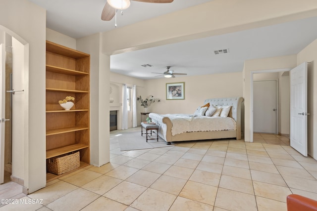 4302 E 6th St, Tucson, AZ 85711 - bedroom featuring light tile patterned floors, a glass covered fireplace, and ceiling fan