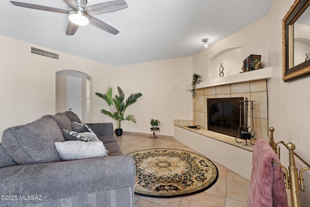 4302 E 6th St, Tucson, AZ 85711 - living room featuring tile patterned floors, arched walkways, a fireplace, ceiling fan, and baseboards