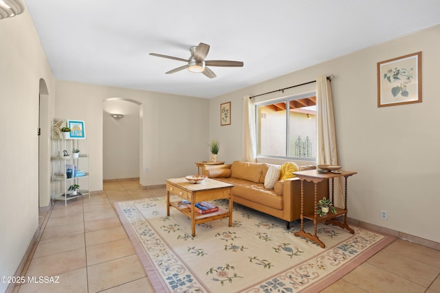 4302 E 6th St, Tucson, AZ 85711 - living room featuring arched walkways, ceiling fan, light tile patterned floors, and baseboards