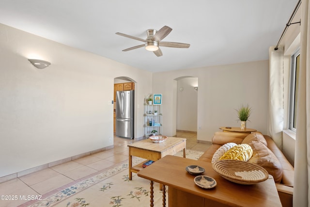 4302 E 6th St, Tucson, AZ 85711 - living area featuring arched walkways, a ceiling fan, light tile patterned flooring, and baseboards