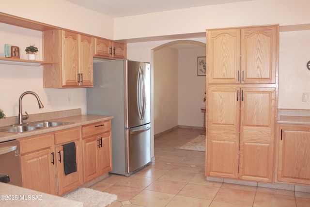 4302 E 6th St, Tucson, AZ 85711 - kitchen featuring a sink, stainless steel appliances, open shelves, light brown cabinets, and arched walkways