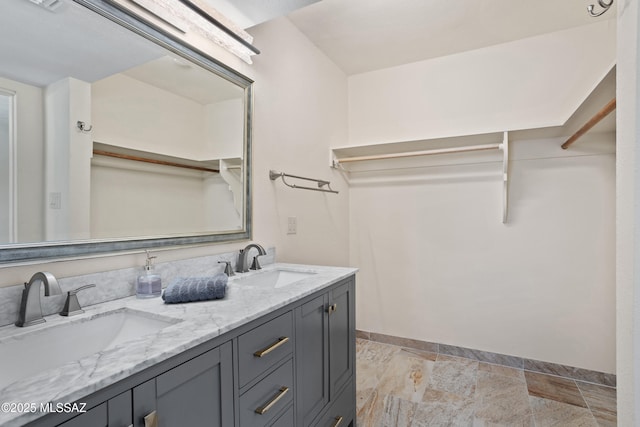4302 E 6th St, Tucson, AZ 85711 - bathroom featuring baseboards, double vanity, and a spacious closet