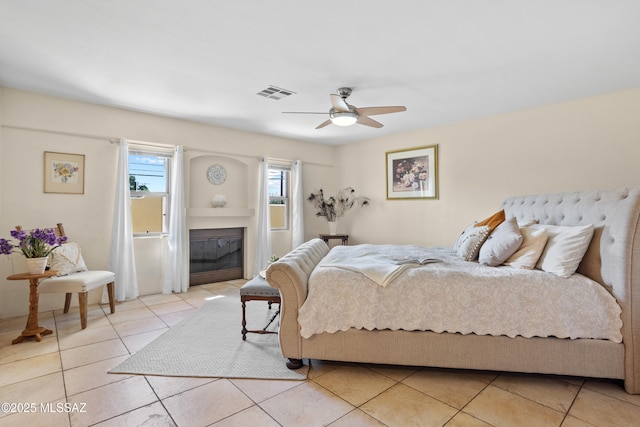 4302 E 6th St, Tucson, AZ 85711 - bedroom featuring light tile patterned flooring, a glass covered fireplace, and a ceiling fan