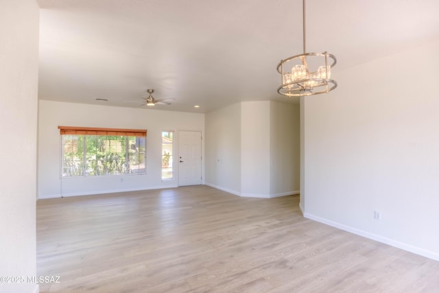 2312 E Coreopsis Way, Oro Valley, AZ 85755 - unfurnished room featuring baseboards, light wood-style flooring, a chandelier, and ceiling fan