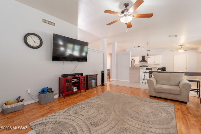 10236 E Rainbow Meadow Dr, Tucson, AZ 85747 - living area featuring a ceiling fan, light wood-type flooring, lofted ceiling, and baseboards