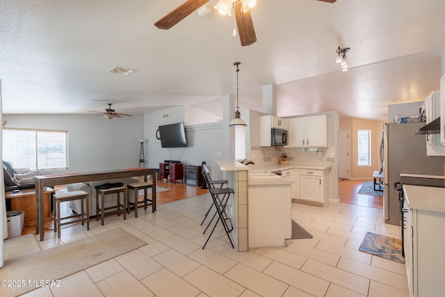10236 E Rainbow Meadow Dr, Tucson, AZ 85747 - kitchen featuring ceiling fan, black microwave, open floor plan, a peninsula, and a breakfast bar