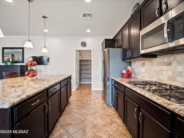 741 S Desert Haven Rd, Vail, AZ 85641 - kitchen with appliances with stainless steel finishes, decorative backsplash, light stone countertops, light tile patterned floors, and decorative light fixtures