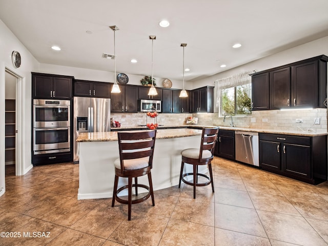 741 S Desert Haven Rd, Vail, AZ 85641 - kitchen featuring appliances with stainless steel finishes, tasteful backsplash, a kitchen island, a sink, and recessed lighting