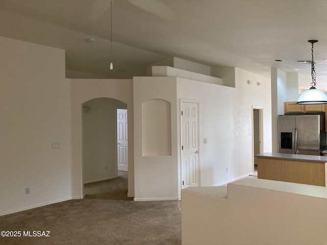 6936 W Sauceda Dr, Tucson, AZ 85743 - unfurnished living room featuring arched walkways, carpet flooring, and baseboards
