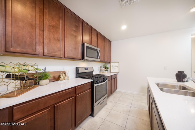 8608 N Genoa Ct, Tucson, AZ 85742 - kitchen featuring stainless steel appliances, a sink, light countertops, light tile patterned floors, and recessed lighting