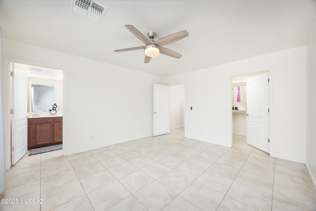 8608 N Genoa Ct, Tucson, AZ 85742 - unfurnished bedroom featuring light tile patterned floors, a spacious closet, a closet, connected bathroom, and baseboards