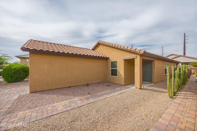 8608 N Genoa Ct, Tucson, AZ 85742 - back of house featuring stucco siding, a tiled roof, and a patio area