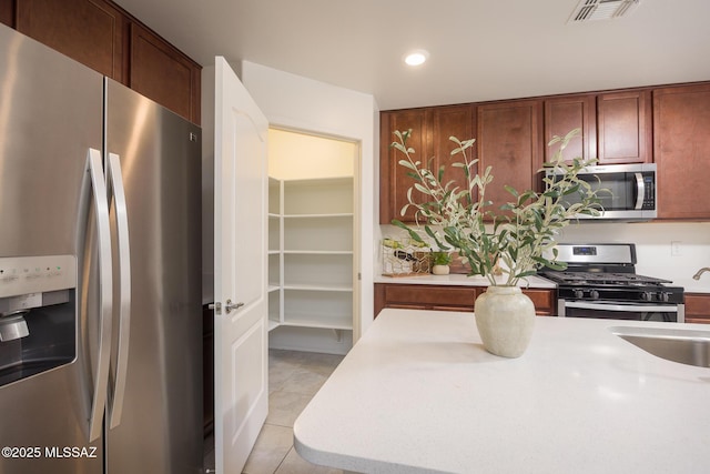 8608 N Genoa Ct, Tucson, AZ 85742 - kitchen featuring stainless steel appliances, a sink, light countertops, light tile patterned floors, and recessed lighting