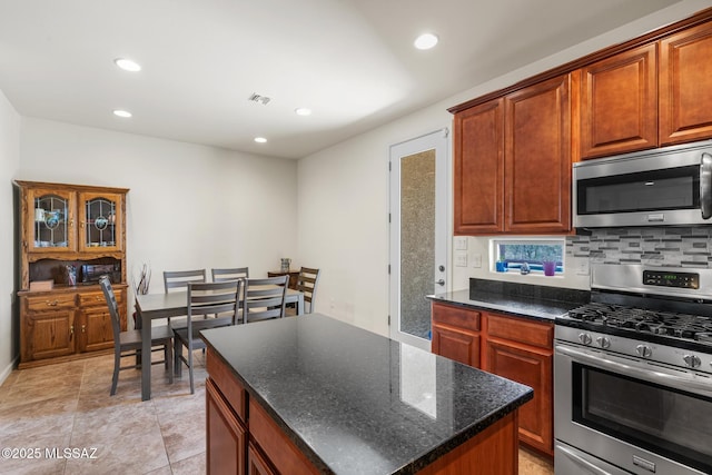 11370 E Creosote Range Dr, Tucson, AZ 85747 - kitchen featuring stainless steel appliances, recessed lighting, a kitchen island, decorative backsplash, and dark stone countertops