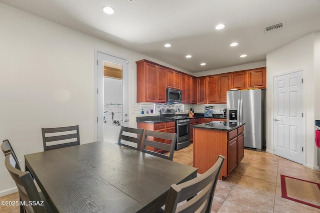 11370 E Creosote Range Dr, Tucson, AZ 85747 - kitchen featuring stainless steel appliances, recessed lighting, dark countertops, a kitchen island, and light tile patterned floors