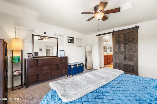 11370 E Creosote Range Dr, Tucson, AZ 85747 - carpeted bedroom featuring a barn door, ensuite bath, and baseboards