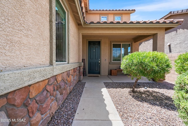 11370 E Creosote Range Dr, Tucson, AZ 85747 - view of exterior entry featuring stucco siding, a tile roof, and stone siding