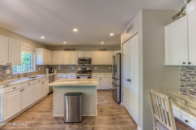 952 S Rincon Rising Rd, Tucson, AZ 85748 - kitchen featuring stainless steel appliances, a sink, backsplash, a kitchen island, and white cabinetry