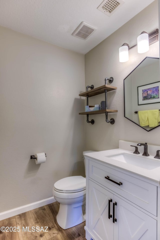 952 S Rincon Rising Rd, Tucson, AZ 85748 - half bathroom featuring toilet, vanity, wood finished floors, and baseboards