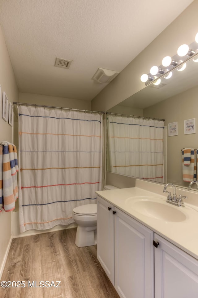 952 S Rincon Rising Rd, Tucson, AZ 85748 - full bathroom featuring vanity, toilet, wood finished floors, a textured ceiling, and a shower with shower curtain