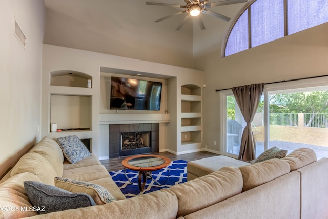 952 S Rincon Rising Rd, Tucson, AZ 85748 - living room featuring a ceiling fan, built in features, wood finished floors, baseboards, and a fireplace