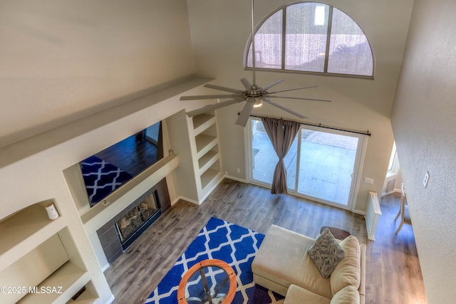 952 S Rincon Rising Rd, Tucson, AZ 85748 - living area with a fireplace, built in shelves, ceiling fan, wood finished floors, and plenty of natural light