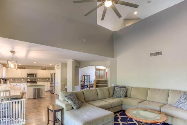 952 S Rincon Rising Rd, Tucson, AZ 85748 - living area featuring arched walkways, ceiling fan, light wood-style floors, recessed lighting, and stairway