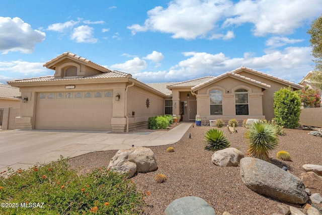 65535 E Rose Ridge Dr, Saddlebrooke, AZ 85739 - mediterranean / spanish-style home featuring a garage, a tile roof, concrete driveway, and stucco siding