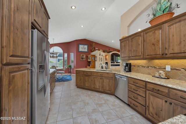 65535 E Rose Ridge Dr, Saddlebrooke, AZ 85739 - kitchen with appliances with stainless steel finishes, a sink, vaulted ceiling, a peninsula, and backsplash